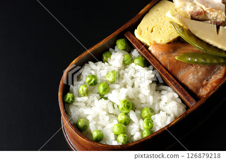 在黑色背景下拍攝的豆米便當盒，裡面有許多配菜 126879218