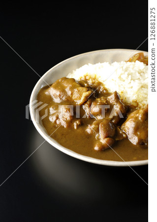 Chicken curry with large chunks of chicken photographed against a black background Chicken curry with large chunks of chicken photographed against a black background 126881275