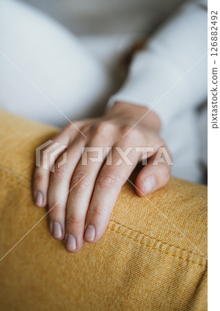 Relaxing Hand Resting on a Comfortable Yellow Couch Relaxing Hand Resting on a Comfortable Yellow Couch 126882492