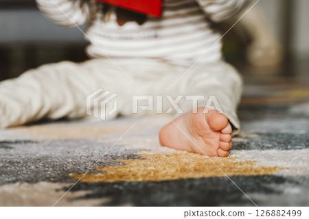Close-Up of Child Reading and Sitting on Carpet Close-Up of Child Reading and Sitting on Carpet 126882499