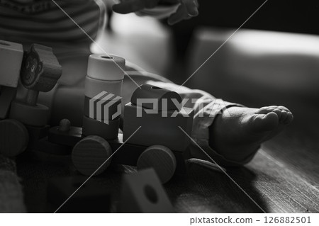 Child Playing with Wooden Toy Train on Floor Child Playing with Wooden Toy Train on Floor 126882501