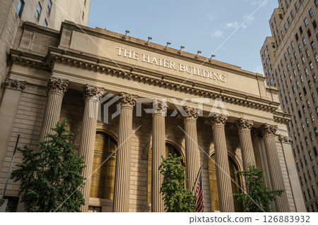 The neoclassical architecture of The Haier Building is captured in golden light. Its tall columns and historic charm stand out among modern surroundings. 126883932