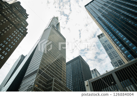 Classic brownstone and reflective glass buildings rise side by side in Manhattan. This business hub blends historic charm with modern structure. 126884004