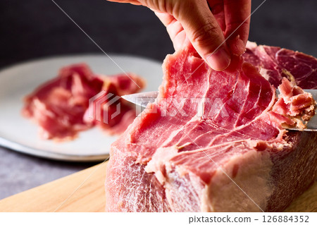 Slicing French block ham by hand 126884352