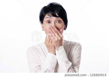 一名中年婦女感到驚訝,並用手摀住嘴 一名中年婦女感到驚訝,並用手摀住嘴 126884914