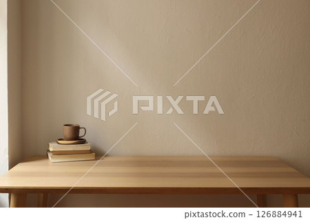 Minimalist elegant interior. Wooden table, stacked vintage books and ceramic coffee, tea cup. Soft natural light, plain beige wall background. Calm cozy atmosphere. Empty copy space. Breakfast concept 126884941