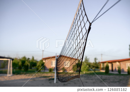 volleyball net stretched across a beach volleyball court 126885182