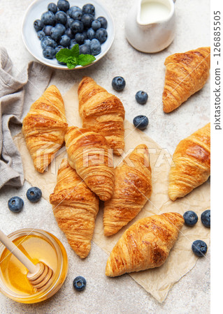 Freshly baked croissants with honey, blueberries, and milk for breakfast Freshly baked croissants with honey, blueberries, and milk for breakfast 126885505