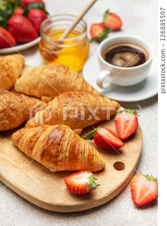 Delicious french breakfast with croissants, coffee, strawberries and honey Delicious french breakfast with croissants, coffee, strawberries and honey 126885507