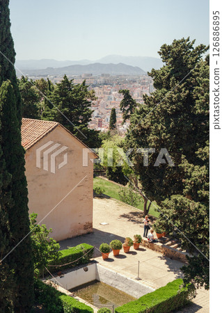 Serene garden with stunning cityscape backdrop, inviting tranquility amidst nature. Serene garden with stunning cityscape backdrop, inviting tranquility amidst nature. 126886895