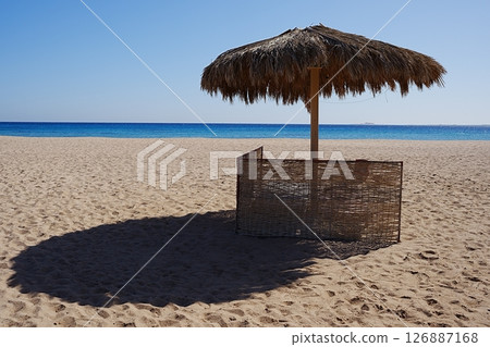 Sunbathing place with umbrella on beach at Red Sea in African SAFAGA city in EGYPT 126887168