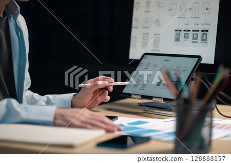 Male coder or developer working overtime using a computer display in problem solving at workplace. 126888157