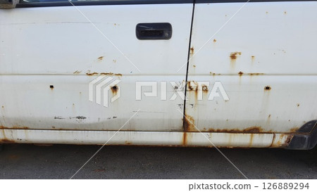 Rusty white car door showing signs of age and corrosion 126889294
