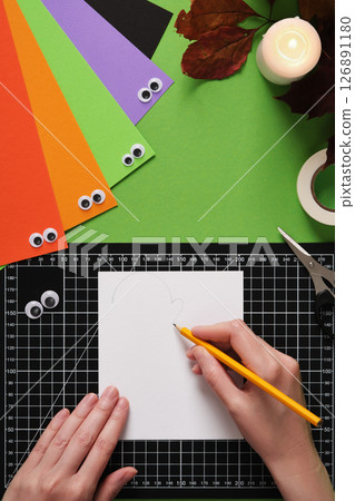 How to make a simple ghost craft. An idea for hobbies and creativity. Draw a random ghost silhouette on white paper with a simple pencil. 126891180