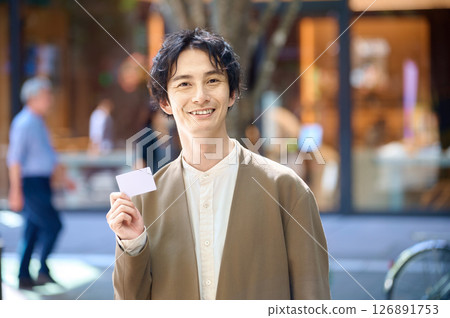 Man holding a shopping card 126891753