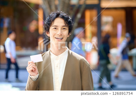 Man holding a shopping card 126891754