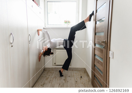 Woman performing a graceful stretching pose with dance elements. Woman performing a graceful stretching pose with dance elements. 126892169