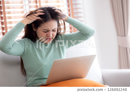 Young asian businesswoman working laptop with stress and frustrated in living room. Young asian businesswoman working laptop with stress and frustrated in living room. 126892248
