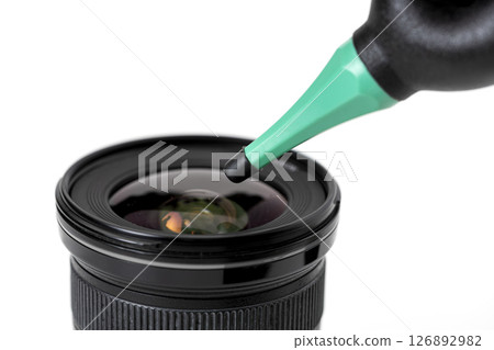 Camera lens being cleaned with dust blower ball, showing close up of lens surface and cleaning tool. image highlights importance of maintaining camera equipment Camera lens being cleaned with dust blower ball, showing close up of lens surface and cleaning tool. image highlights importance of maintaining camera equipment 126892982