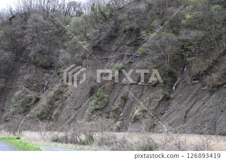 Cliffs along a river with a small waterfall Cliffs along a river with a small waterfall 126893419