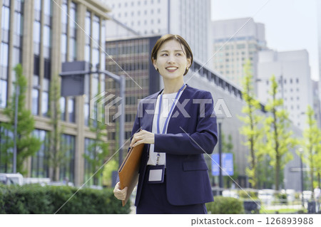 一位年輕的女商人在辦公區拿著活頁夾 126893988