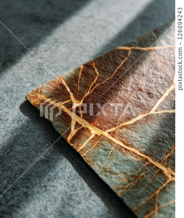 Leathered soapstone slab with warm brown and gold veining on textured greenish background Leathered soapstone slab with warm brown and gold veining on textured greenish background 126894243
