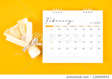 2026 February desk calendar and Yellow bouquet on yellow background. 126894645