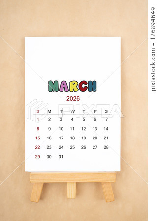 Calendar page for March 2026 with wood easel on old brown background. 126894649