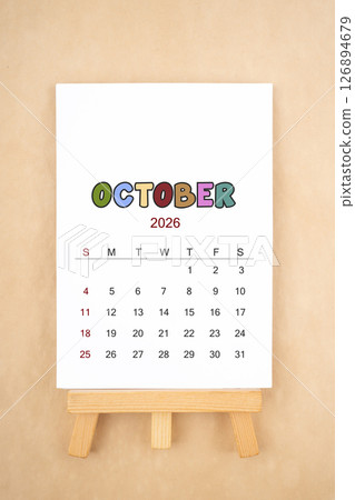 Calendar page for October 2026 with wood easel on old brown background. 126894679