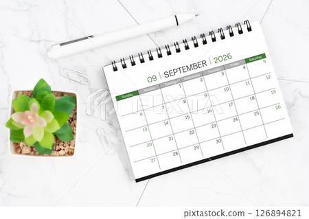 Desk calendar on month of September 2026 with pen on white marble background. 126894821