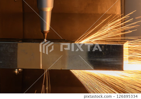 Close up scene the fiber laser cutting machine cut the square shape stainless steel tube with sparkling light. Close up scene the fiber laser cutting machine cut the square shape stainless steel tube with sparkling light. 126895334