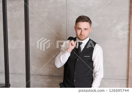 Man wearing a black vest and a white shirt 126895744