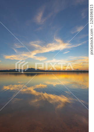 Landscape of mountains and lake at sunset and clouds reflected in the water. Landscape of mountains and lake at sunset and clouds reflected in the water. 126896915