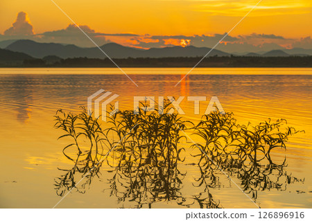 Landscape of mountains and lake at sunset and clouds reflected in the water. Landscape of mountains and lake at sunset and clouds reflected in the water. 126896916