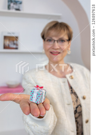 Woman hands holding gift box with red bow, close-up. Vertical photo. High quality photo Woman hands holding gift box with red bow, close-up. Vertical photo. High quality photo 126897618