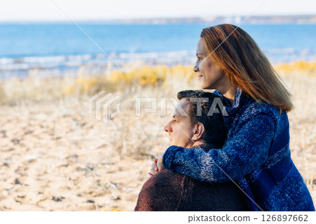 Loving couple walks on beach along sea on sunny autumn day. Weekend and lifestyle concept. High quality photo 126897662