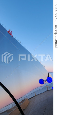 stylish boardwalk featuring a contemporary architectural design with striking blue light spheres. Reflective surfaces enhance the structure against a clear sky backdrop stylish boardwalk featuring a contemporary architectural design with striking blue light spheres. Reflective surfaces enhance the structure against a clear sky backdrop 126897700