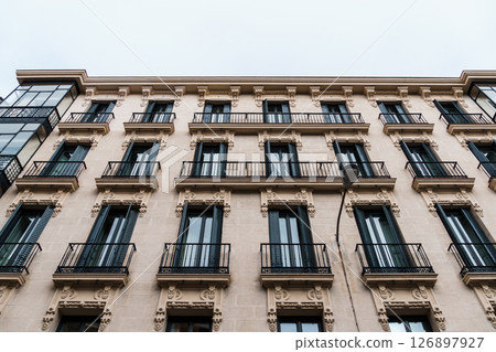 Classic Madrid apartment building with ornate facade and black wrought-iron balconies. Classic Madrid apartment building with ornate facade and black wrought-iron balconies. 126897927