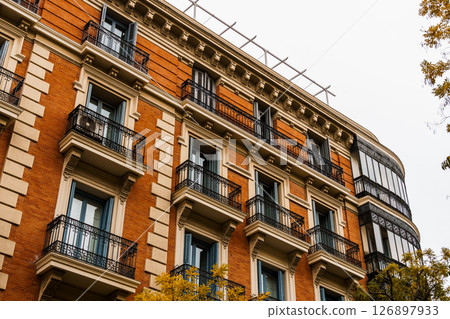 Charming residential building in Madrid featuring classic balconies and elegant architecture. Charming residential building in Madrid featuring classic balconies and elegant architecture. 126897933