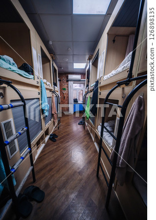 Capsule hotel room showing multiple single beds and wooden floor 126898135