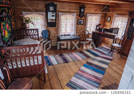 Rustic charm fills a traditional russian wooden house interior, featuring period furniture, colorful rugs, and nostalgic decor 126898181