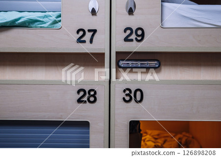 Modern capsule hotel offering comfortable and private sleeping pods 126898208