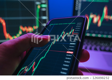 businessman using trading application on smartphone with stock market charts 126898232
