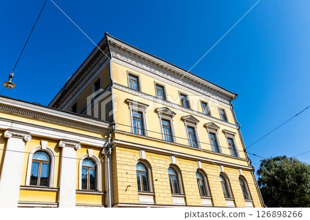 Bright yellow building in Helsinki, Finland, viewed from a low angle against a clear blue sky. Bright yellow building in Helsinki, Finland, viewed from a low angle against a clear blue sky. 126898266