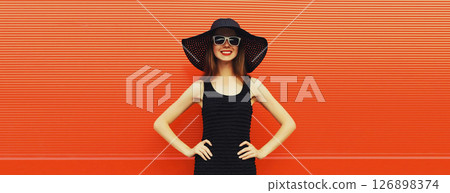 Summer portrait of beautiful stylish young woman posing in hat, glasses on bright red background 126898374