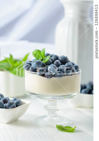 Mascarpone cream with fresh blueberries in a clear bowl. Mascarpone cream with fresh blueberries in a clear bowl. 126898413