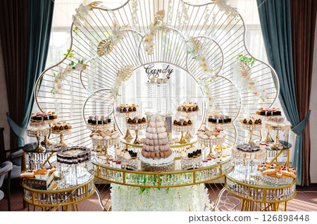 Delicious macarons and pastries decorating a luxurious candy bar buffet Delicious macarons and pastries decorating a luxurious candy bar buffet 126898448
