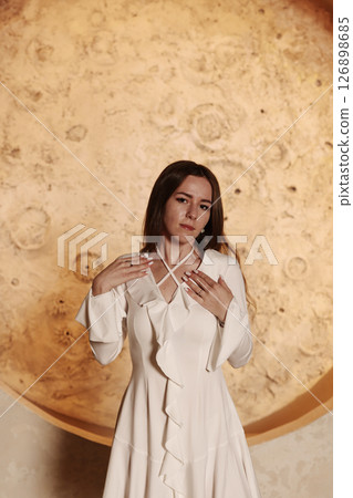 An Elegant Woman in a Stunning White Dress Posing Against a Beautiful Moon Background An Elegant Woman in a Stunning White Dress Posing Against a Beautiful Moon Background 126898685