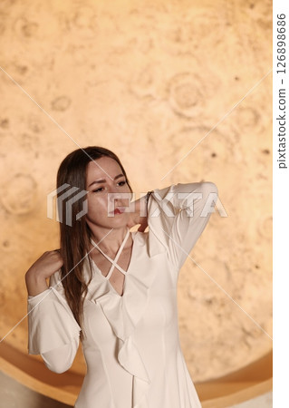 A Beautiful and Elegant Woman Posing Gracefully in a Chic White Dress with Flair and Style 126898686