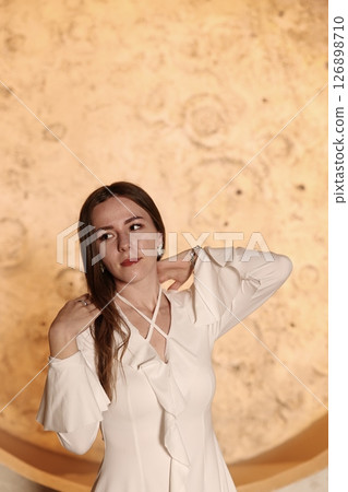 A Chic Woman Posing Elegantly Against a Beautifully Textured and Visually Appealing Background 126898710